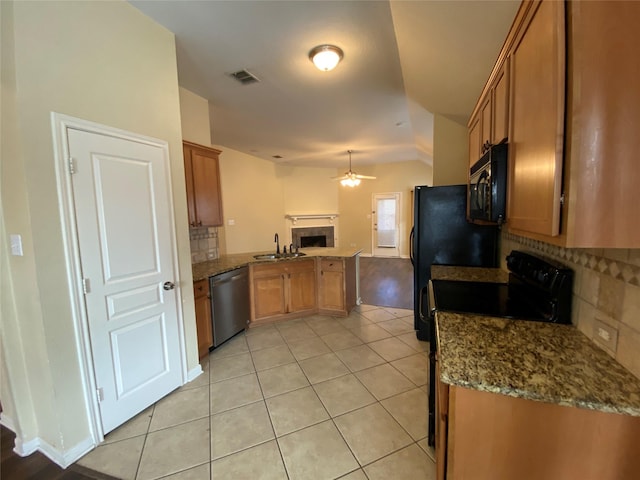 kitchen with light tile patterned flooring, a sink, a peninsula, decorative backsplash, and black appliances
