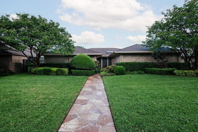 view of front facade with a front lawn and brick siding