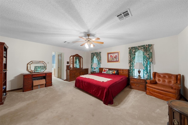 carpeted bedroom featuring a textured ceiling, ceiling fan, and visible vents