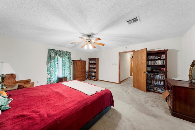 carpeted bedroom featuring a ceiling fan, a textured ceiling, visible vents, and baseboards