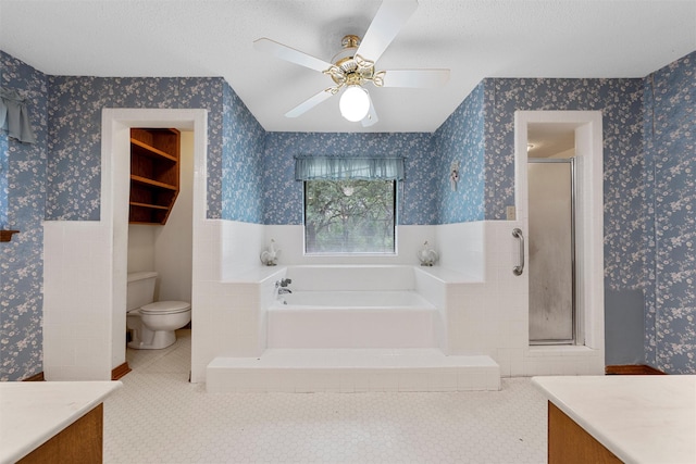 bathroom with vanity, a stall shower, wainscoting, and wallpapered walls