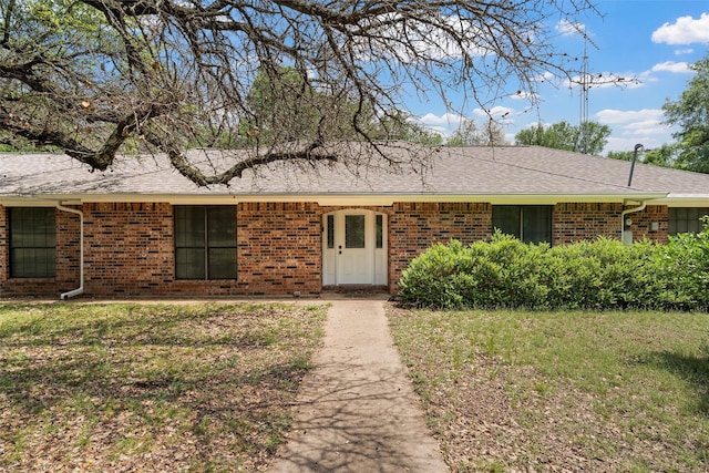 ranch-style home with brick siding and a shingled roof