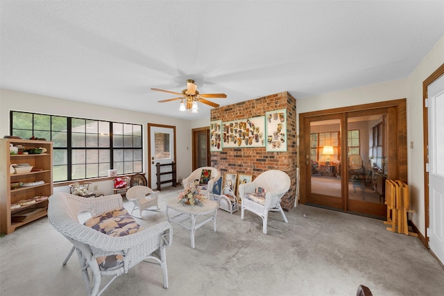 living room with a ceiling fan, brick wall, and french doors