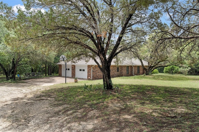 view of front of home featuring brick siding, driveway, and a front yard