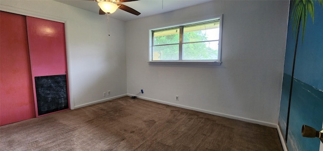 carpeted empty room featuring baseboards and a ceiling fan