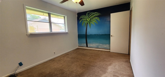 unfurnished room with carpet floors, a ceiling fan, and baseboards