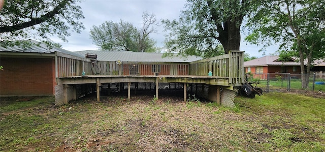 rear view of property with brick siding, fence, a wooden deck, and metal roof