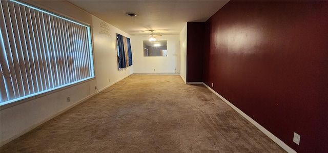 corridor featuring baseboards and carpet flooring