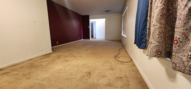 carpeted spare room with baseboards