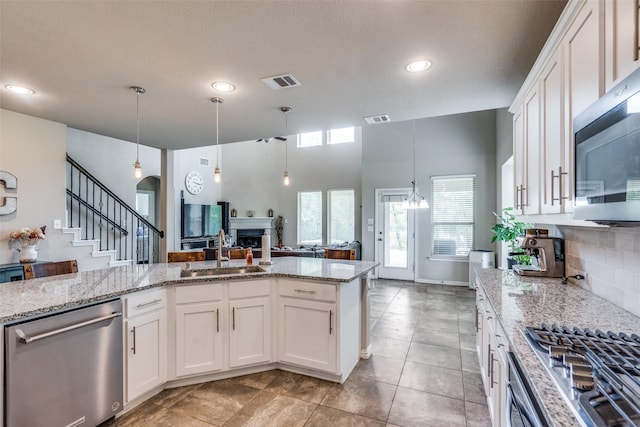 1821 Beacon Beach Way, Wylie, TX 75098 - kitchen featuring a sink, stainless steel appliances, white cabinets, light stone countertops, and recessed lighting