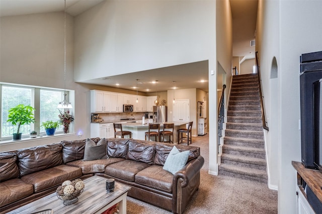 1821 Beacon Beach Way, Wylie, TX 75098 - living area featuring a towering ceiling, light carpet, stairs, and baseboards