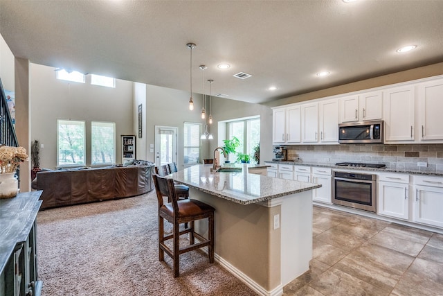 1821 Beacon Beach Way, Wylie, TX 75098 - kitchen with appliances with stainless steel finishes, a sink, open floor plan, light stone counters, and white cabinetry