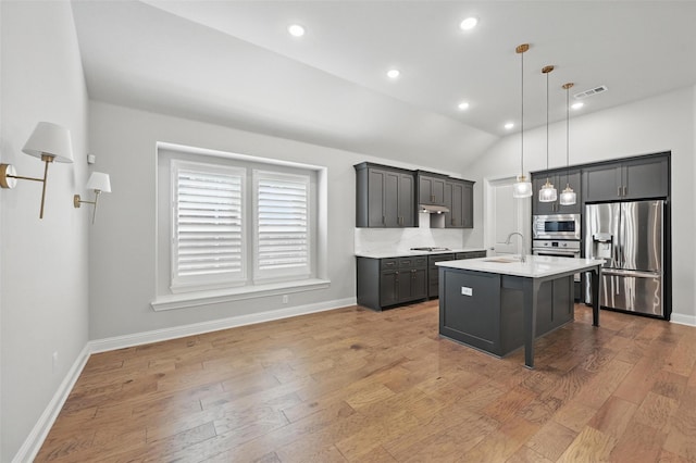 kitchen with visible vents, appliances with stainless steel finishes, hanging light fixtures, a sink, and light countertops