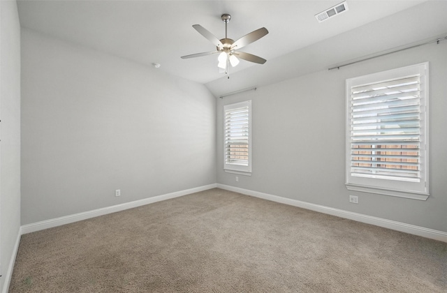 carpeted spare room with baseboards, ceiling fan, lofted ceiling, and visible vents
