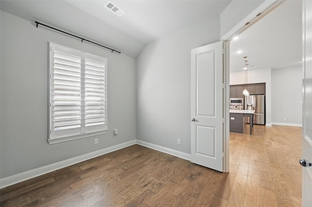 unfurnished room featuring baseboards, visible vents, a healthy amount of sunlight, and light wood finished floors