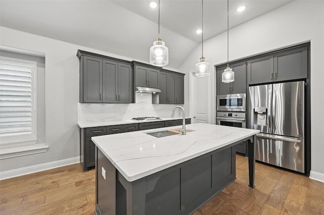 kitchen with a sink, appliances with stainless steel finishes, baseboards, and tasteful backsplash