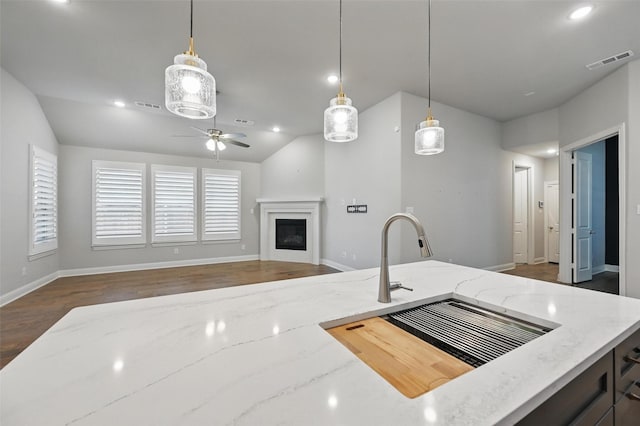 kitchen with visible vents, a glass covered fireplace, ceiling fan, and lofted ceiling