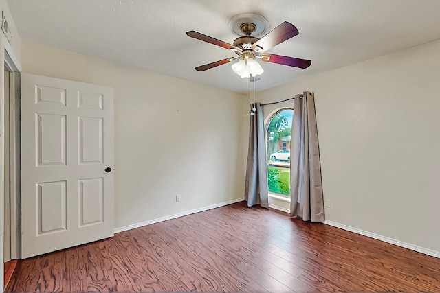 empty room featuring baseboards, a ceiling fan, and wood finished floors