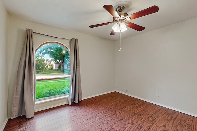 empty room featuring baseboards, a ceiling fan, and wood finished floors