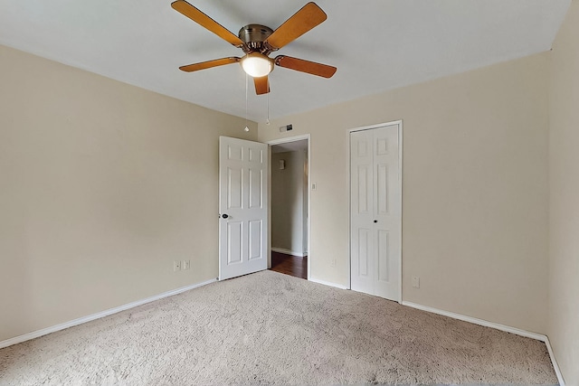 unfurnished bedroom featuring visible vents, a closet, baseboards, ceiling fan, and carpet