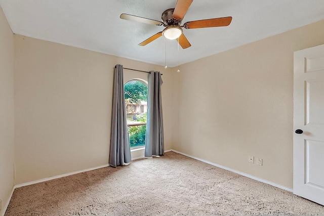 spare room with a ceiling fan, baseboards, and light carpet