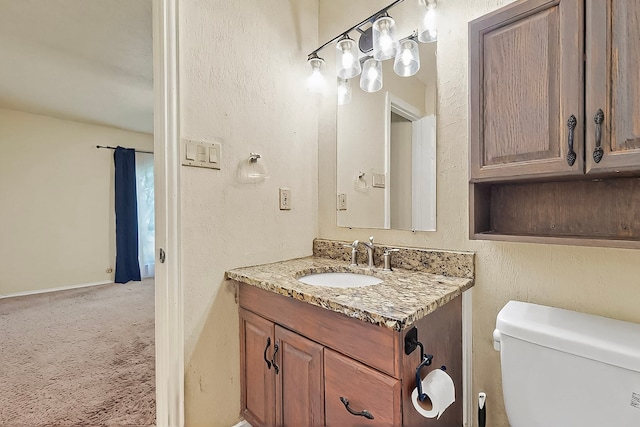 half bathroom featuring vanity and toilet