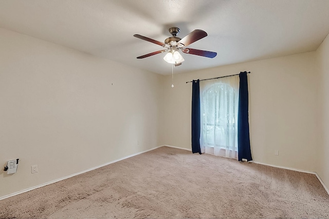 empty room featuring baseboards, a ceiling fan, and light colored carpet