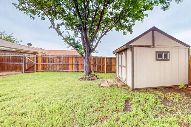 view of yard with a fenced backyard, an outdoor structure, and a storage shed