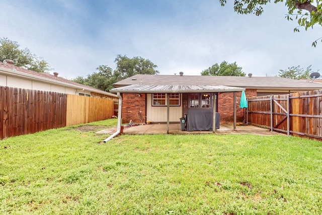 back of property with a fenced backyard, a patio, a yard, and brick siding
