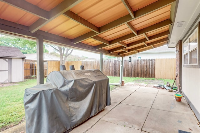 view of patio with grilling area, a fenced backyard, a storage shed, visible vents, and an outbuilding