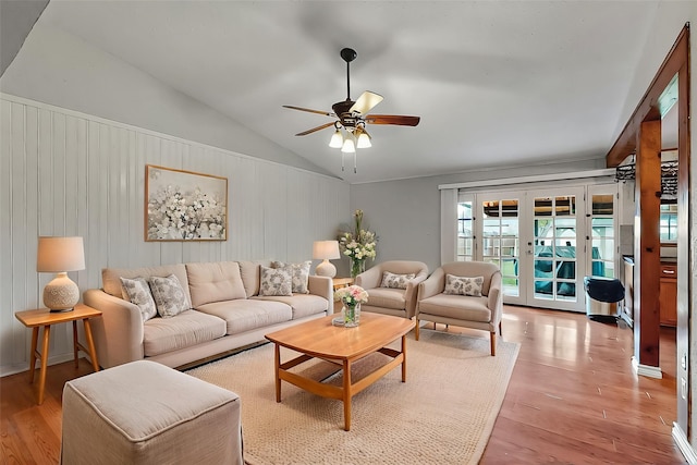 living area with light wood-style floors, a ceiling fan, french doors, and lofted ceiling