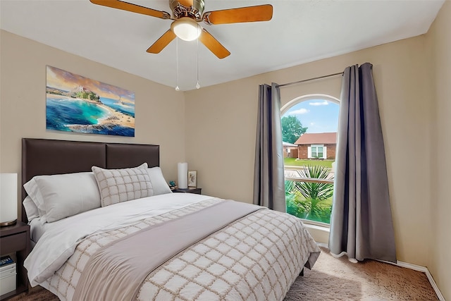 bedroom with baseboards, a ceiling fan, and light carpet