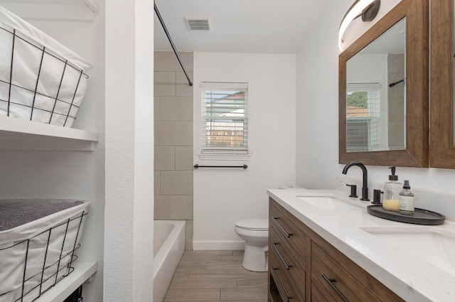 full bath featuring plenty of natural light, toilet, vanity, and bathtub / shower combination