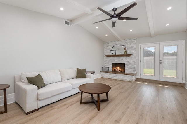 living area featuring light wood finished floors, a ceiling fan, baseboards, a stone fireplace, and recessed lighting