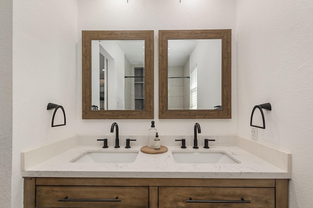bathroom featuring double vanity and a textured wall