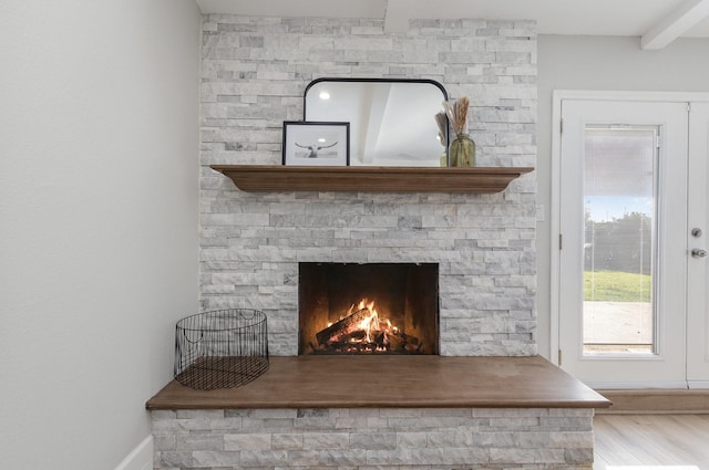 detailed view of baseboards, wood finished floors, and a fireplace