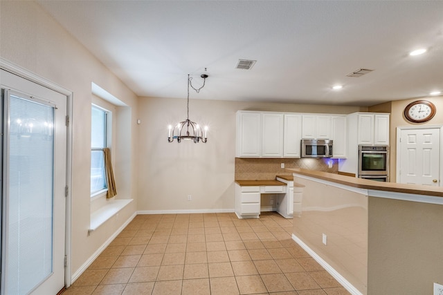 kitchen with visible vents, white cabinetry, appliances with stainless steel finishes, and tasteful backsplash