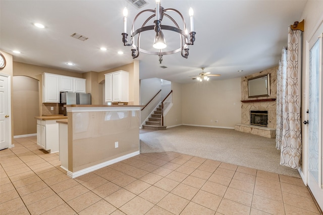 kitchen featuring visible vents, a fireplace, light tile patterned flooring, and light colored carpet