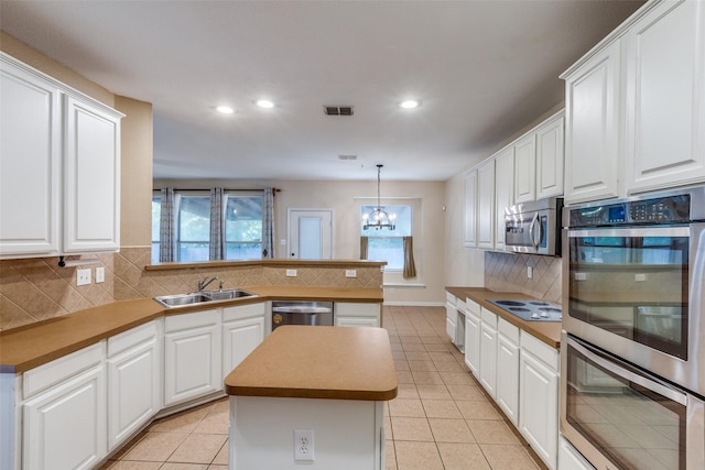 kitchen with visible vents, decorative backsplash, a healthy amount of sunlight, a sink, and appliances with stainless steel finishes