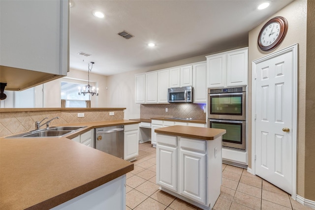 kitchen with visible vents, white cabinets, tasteful backsplash, a sink, and appliances with stainless steel finishes