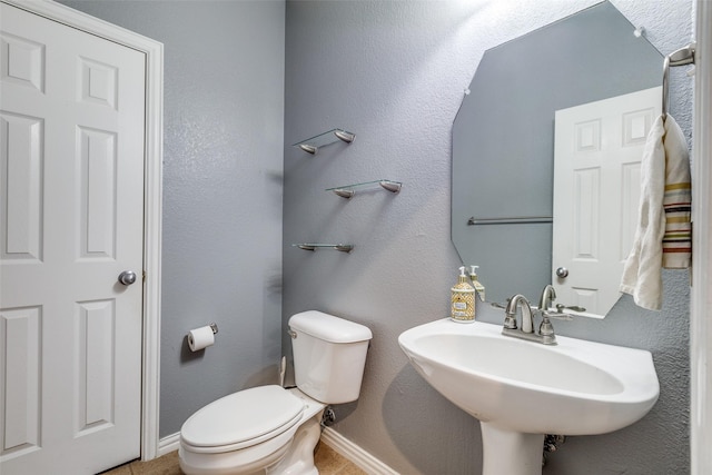 bathroom with baseboards, a sink, and toilet