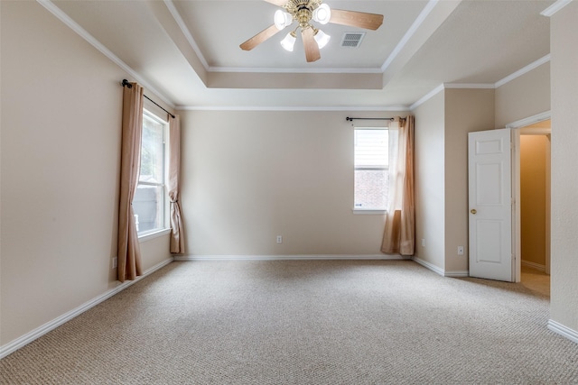 unfurnished room with a ceiling fan, a tray ceiling, visible vents, and light colored carpet