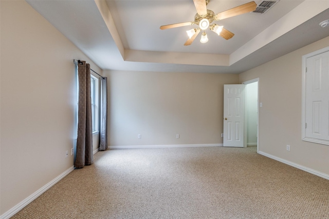 spare room featuring carpet floors, baseboards, and visible vents