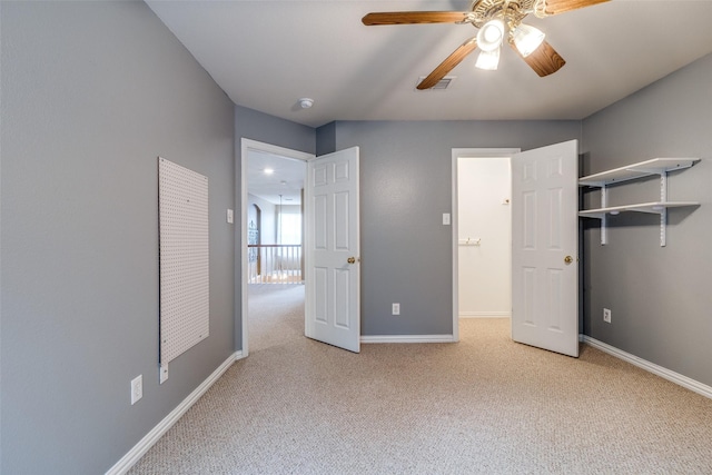 unfurnished bedroom featuring baseboards, carpet, a ceiling fan, and visible vents