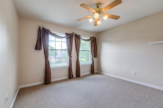 spare room featuring baseboards, ceiling fan, and light carpet