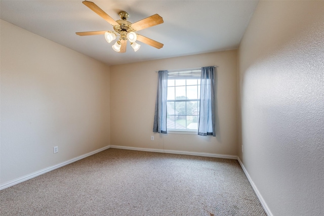 unfurnished room with carpet floors, a ceiling fan, and baseboards