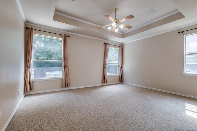 unfurnished room featuring crown molding, a tray ceiling, and visible vents