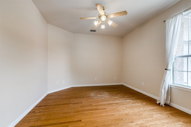 empty room with a ceiling fan, baseboards, visible vents, and light wood finished floors