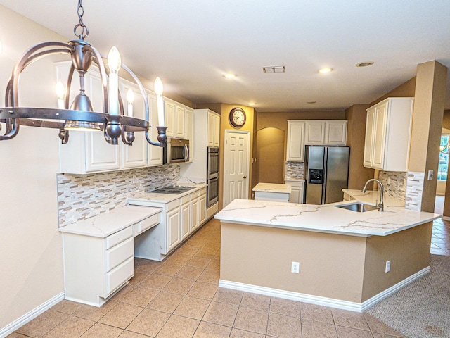 5320 Alta Loma Dr, Fort Worth, TX 76244 - kitchen featuring appliances with stainless steel finishes, tasteful backsplash, arched walkways, a peninsula, and light stone countertops