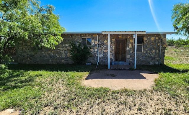 view of front of home with a front lawn and stone siding